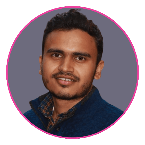 Puneet smiling, wearing a blue textured sweater over a checkered shirt