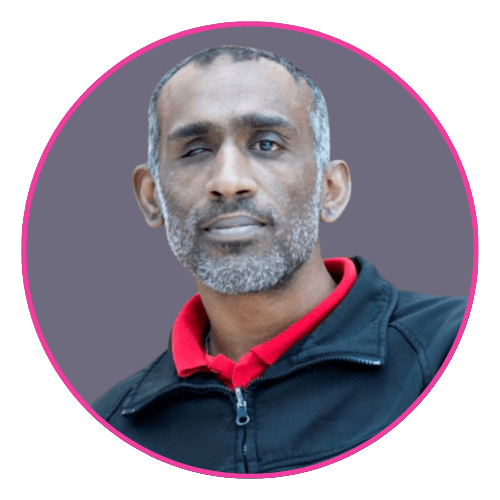 Mohammad smiling, wearing a black jacket over a red collared shirt.