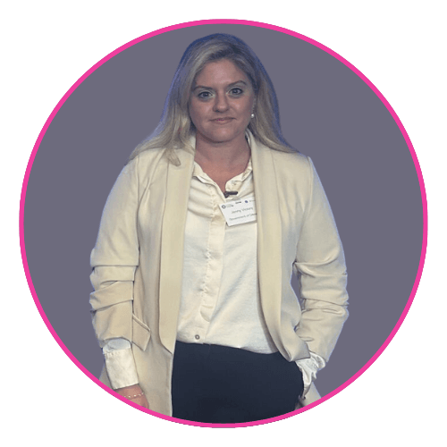 Jenny standing against a muted purple background, wearing a light blazer and name tag.