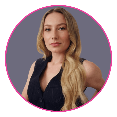 Keely with long wavy blonde hair, wearing a sleeveless dark pinstriped top and a neutral expression.