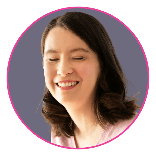 Ellie Wallwork smiling with eyes closed, wearing a light pink top and shoulder-length dark brown hair. UK-based actor, activist, and inclusion advocate.
