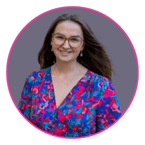 Kirstie smiling outdoors in a vibrant floral dress.